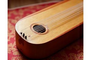 A beautifully crafted gayageum, a traditional Korean zither, being played by an instructor.